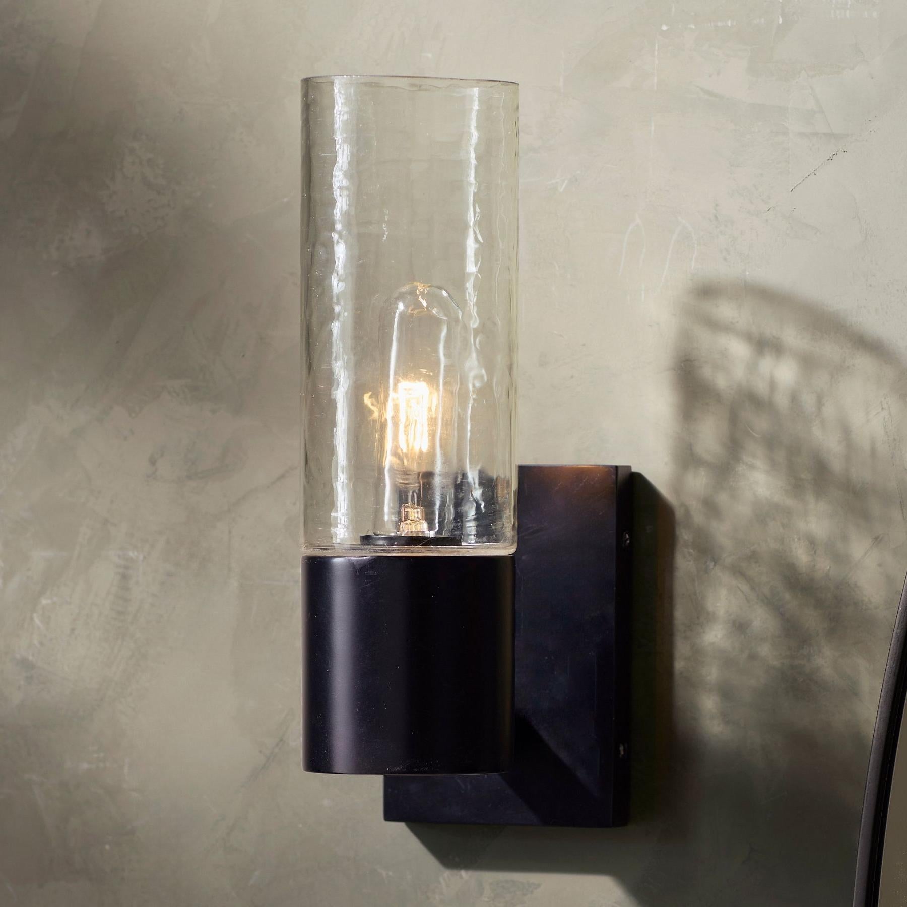Gros plan sombre sur la lampe de coiffeuse Evren avec l'ampoule allumée
