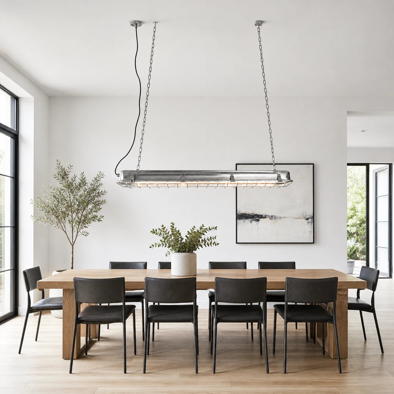 Lámpara colgante lineal sobre una mesa de comedor larga.