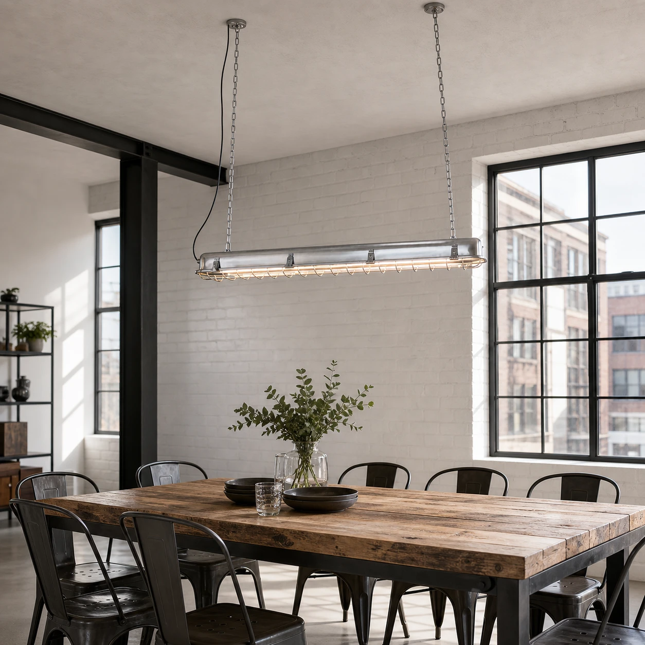 Lámpara colgante lineal en el comedor de un loft industrial.